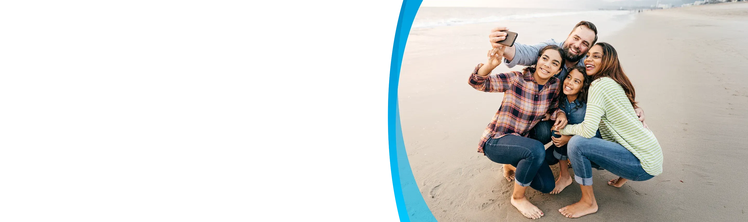 family with cell phone on the beach
